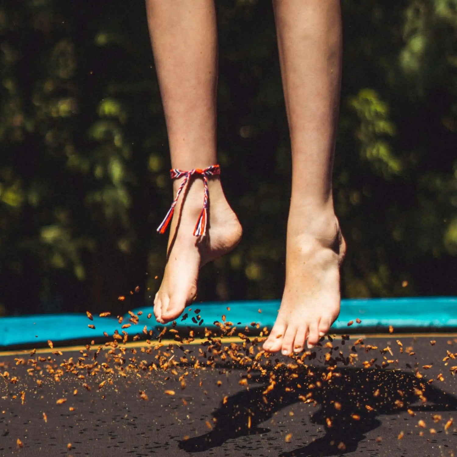 Bare feet jumping on a trampoline.